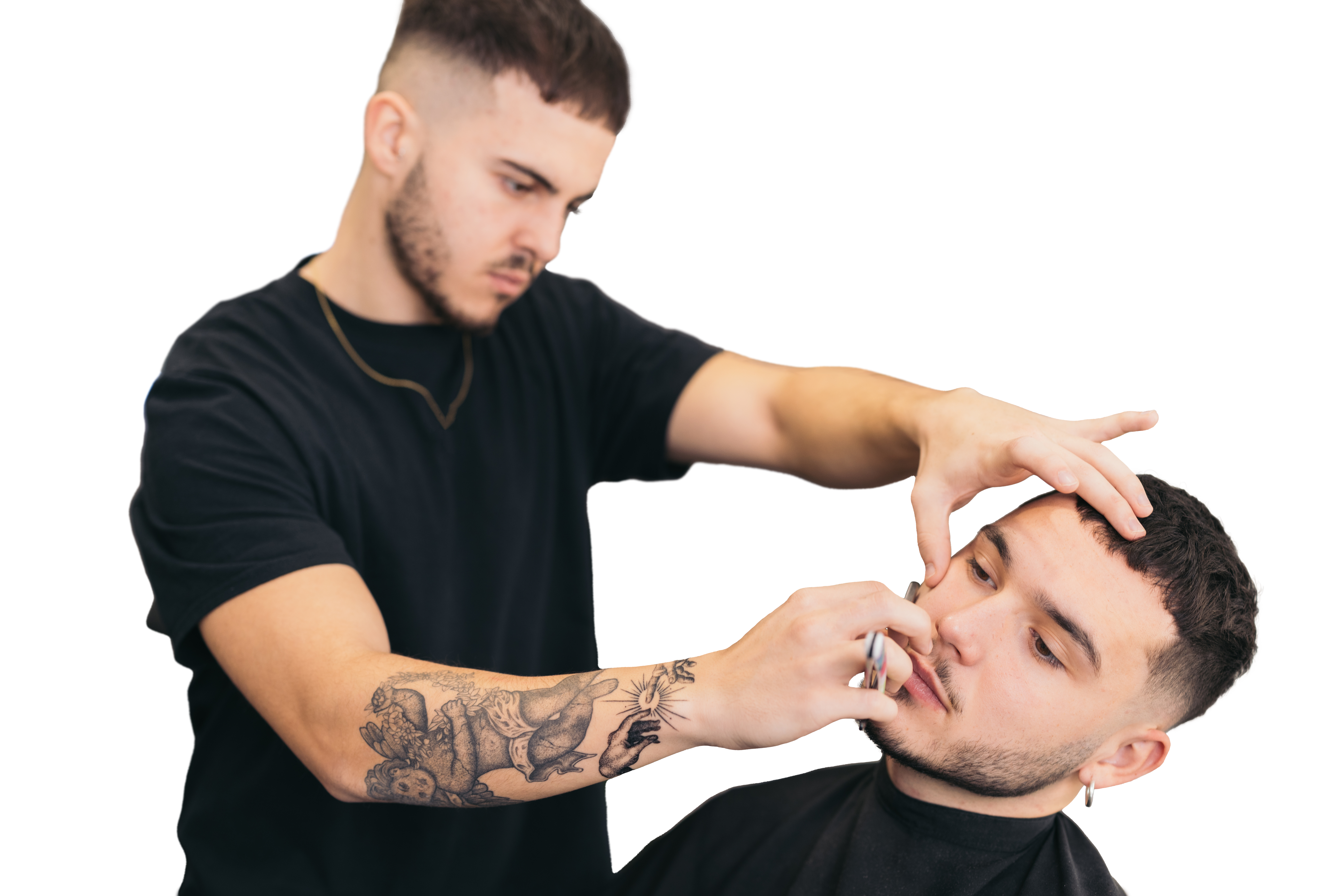 A professional barber shaving a client’s beard.