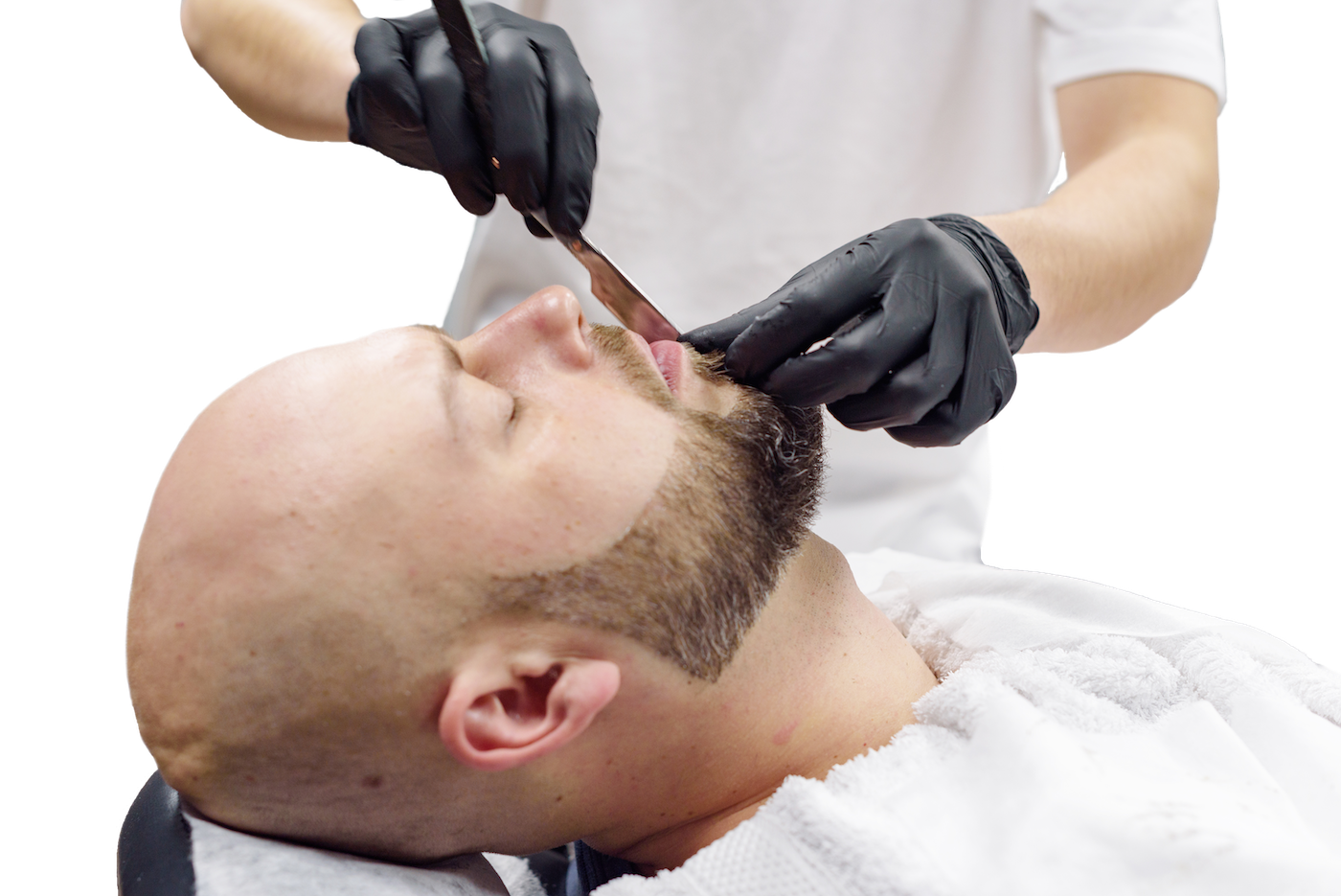 A professional barber lining up a client’s beard.