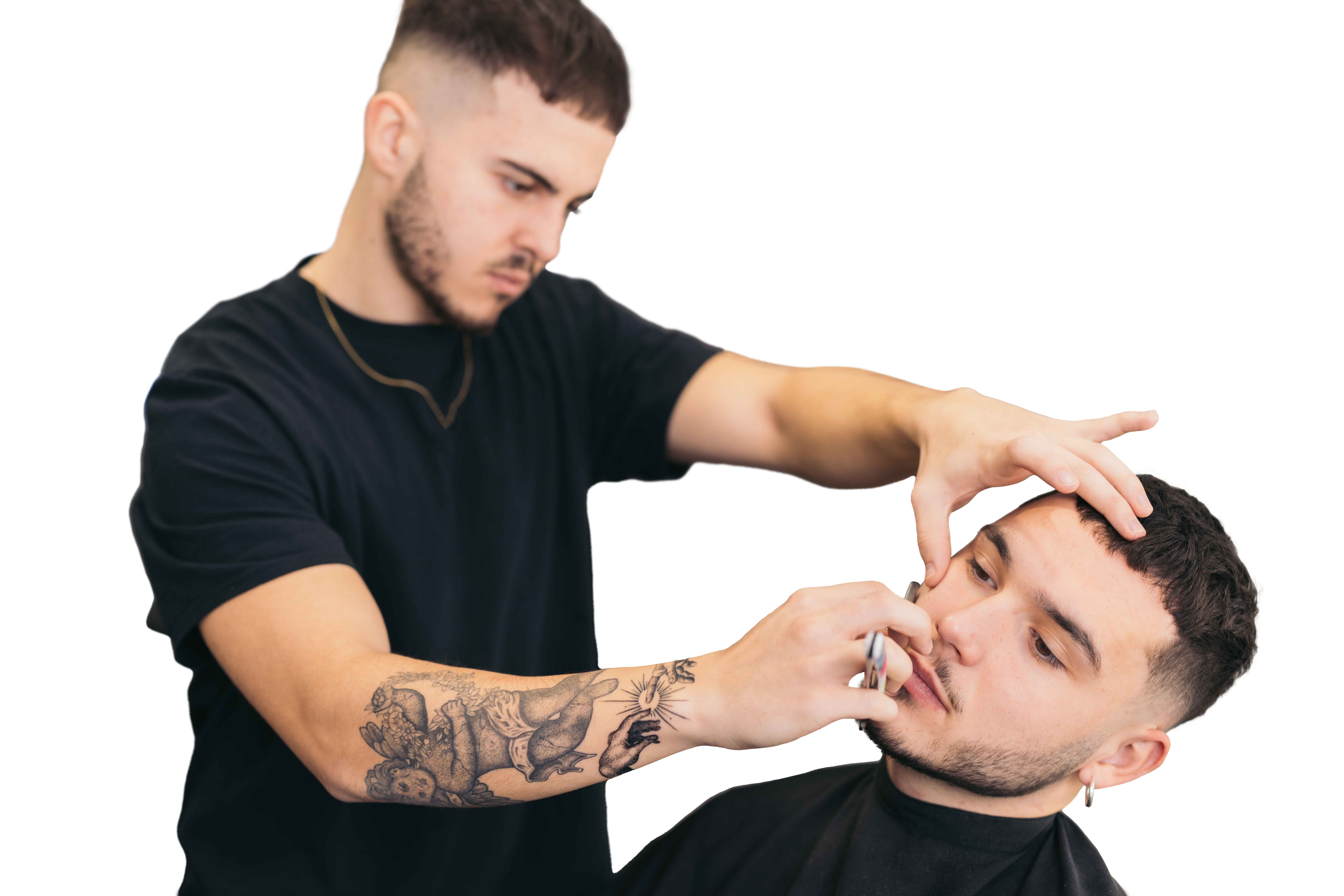A professional barber shaving a client’s beard. 